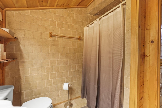 bathroom with toilet, vaulted ceiling, tile walls, and wooden ceiling