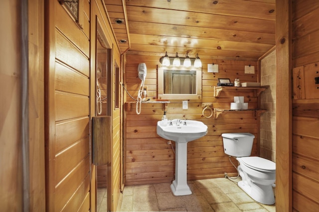 bathroom with toilet, wooden ceiling, and wood walls