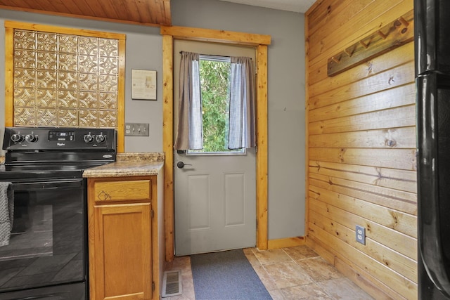 doorway featuring light tile patterned floors and wood walls