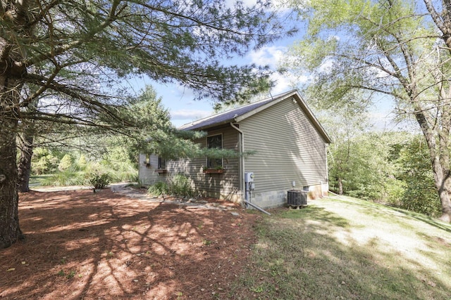 view of home's exterior featuring central AC unit and a yard