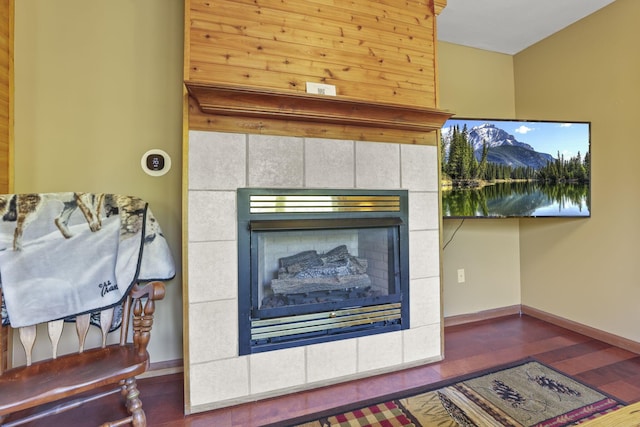 details featuring a tiled fireplace and hardwood / wood-style flooring