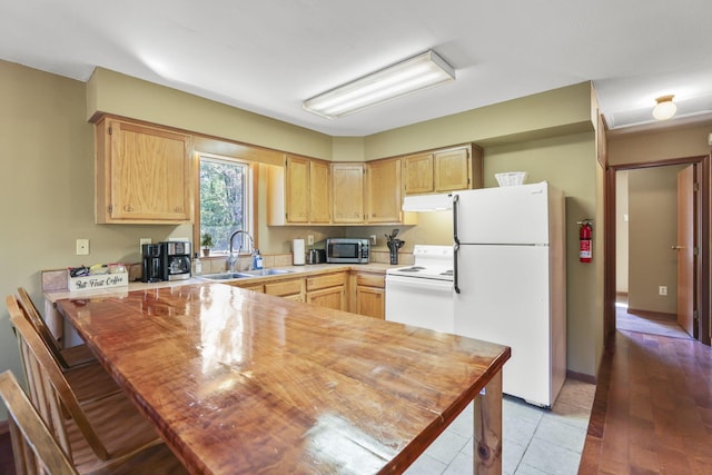 kitchen featuring sink, light hardwood / wood-style flooring, white appliances, and light brown cabinets