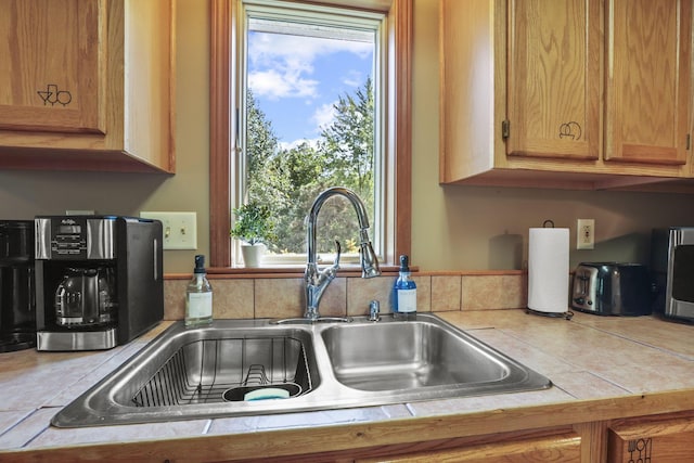 kitchen featuring tile counters and sink