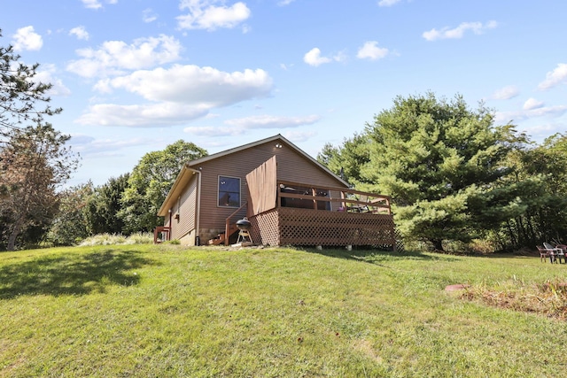 view of side of home featuring a yard and a wooden deck