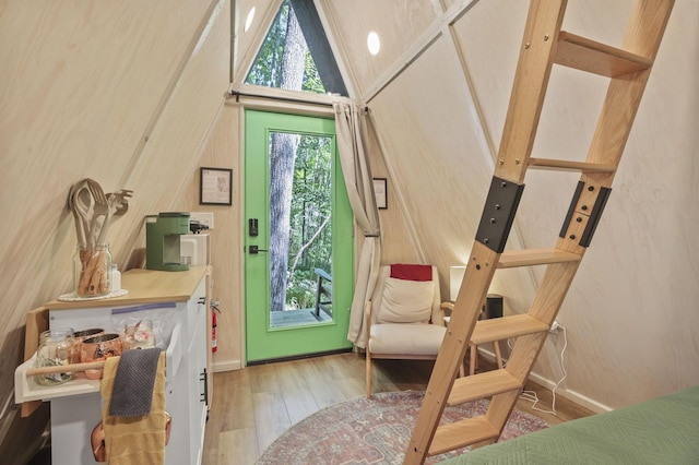 doorway with a towering ceiling and light hardwood / wood-style floors