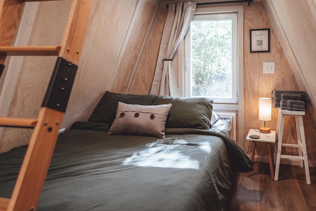 bedroom featuring wooden walls and hardwood / wood-style floors