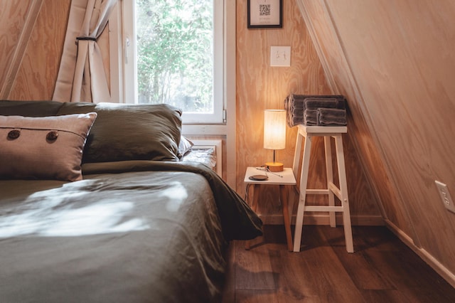 bedroom featuring wood walls and hardwood / wood-style flooring