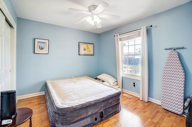 bedroom with a closet, hardwood / wood-style flooring, and ceiling fan