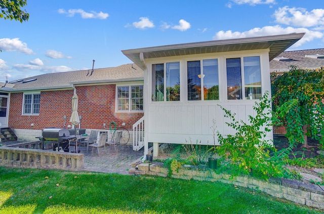 rear view of property featuring a yard and a patio