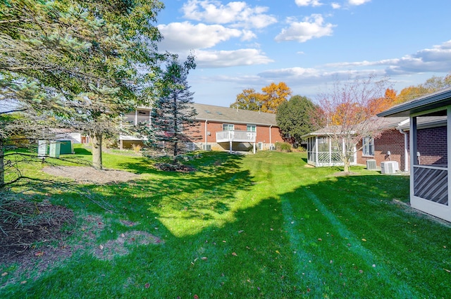 view of yard with a sunroom and central AC unit