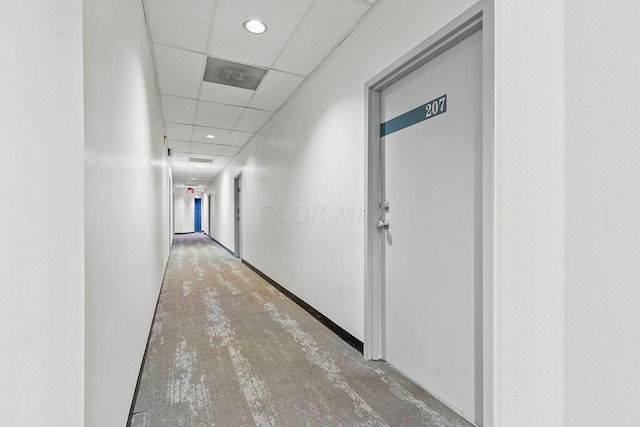 corridor with a paneled ceiling