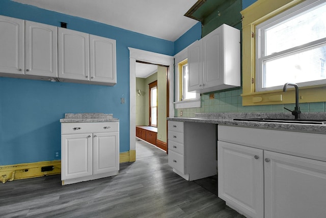 kitchen with white cabinets, dark hardwood / wood-style floors, backsplash, and sink