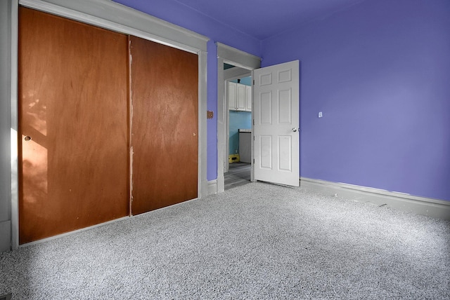 unfurnished bedroom featuring carpet and a closet