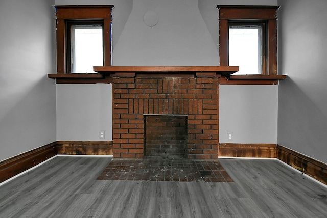 details with hardwood / wood-style flooring and a brick fireplace