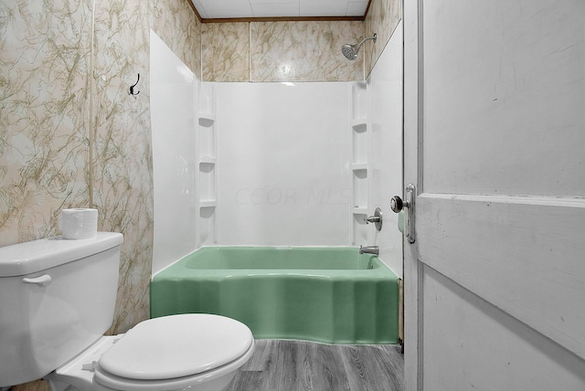 bathroom with bathing tub / shower combination, toilet, and hardwood / wood-style flooring