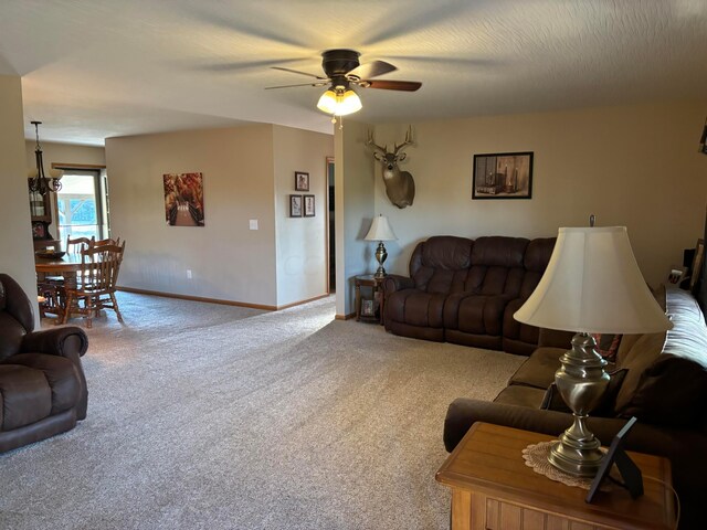 carpeted living room featuring ceiling fan and a textured ceiling