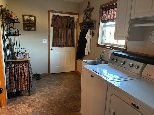 clothes washing area featuring cabinets, washing machine and clothes dryer, and sink