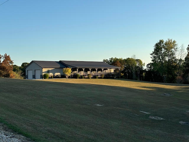 view of front of home featuring a front yard, a garage, and an outdoor structure