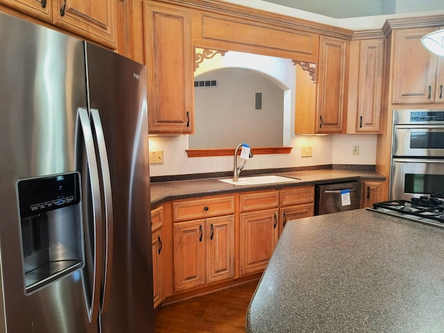 kitchen with sink, stainless steel appliances, and dark wood-type flooring