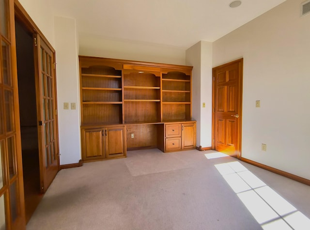 unfurnished office featuring french doors and light colored carpet