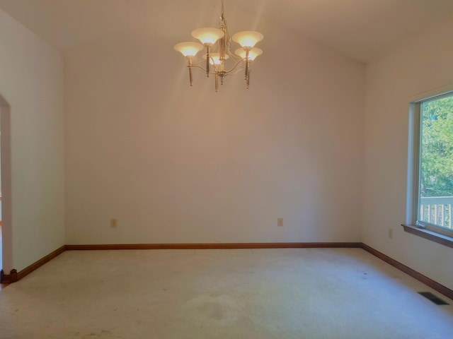 carpeted spare room featuring lofted ceiling and a notable chandelier