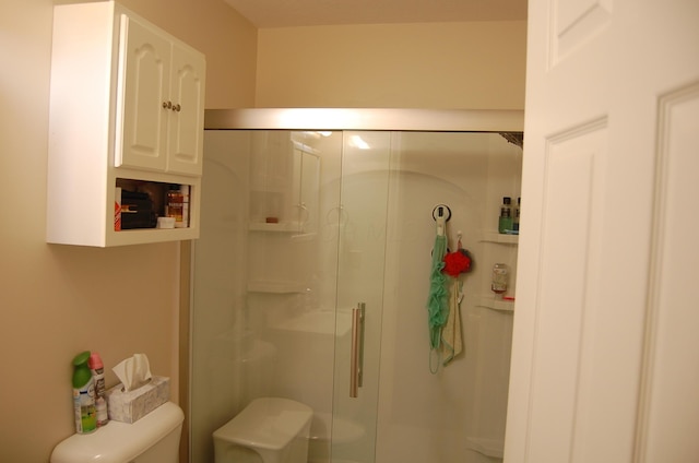 bathroom with toilet and a shower with shower door