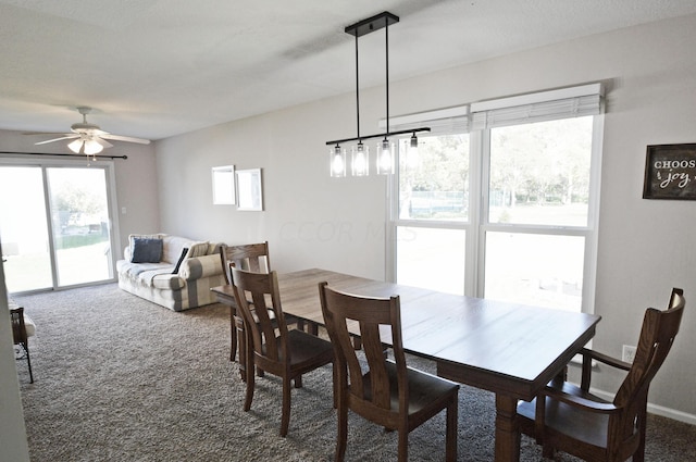 dining area with a wealth of natural light, ceiling fan, and dark carpet