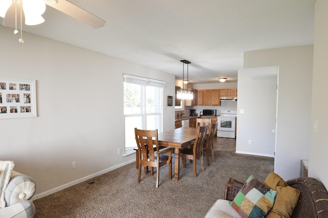 carpeted dining area featuring ceiling fan