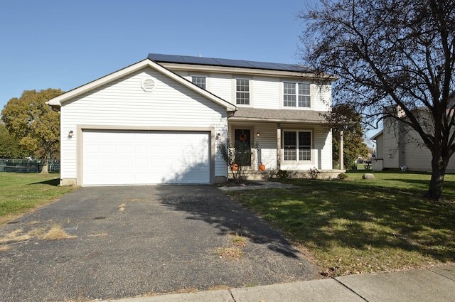 view of front of house with a garage, a front yard, and solar panels