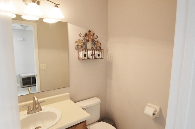 bathroom with vanity, toilet, and heating unit