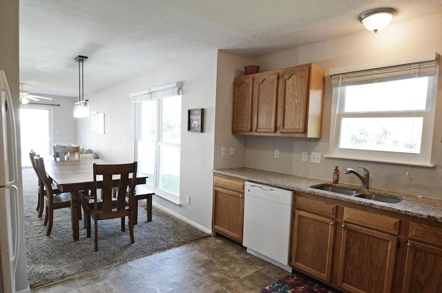 kitchen with white appliances, decorative light fixtures, a healthy amount of sunlight, and sink