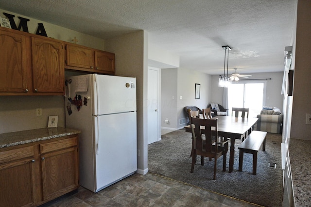 kitchen featuring ceiling fan, white fridge, and a textured ceiling