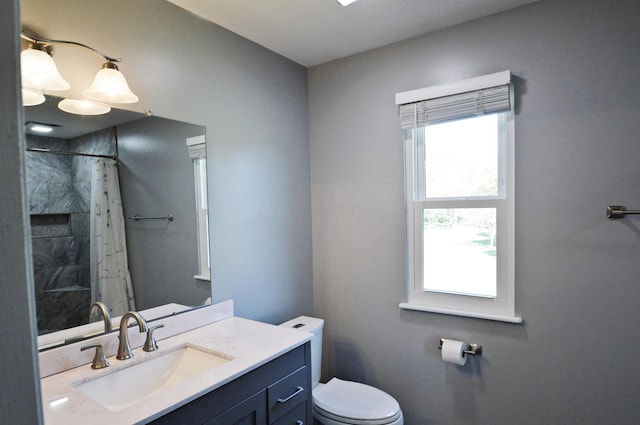 bathroom with a shower with shower curtain, vanity, toilet, and a wealth of natural light