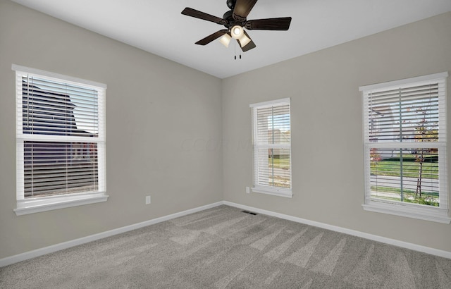 carpeted spare room featuring ceiling fan