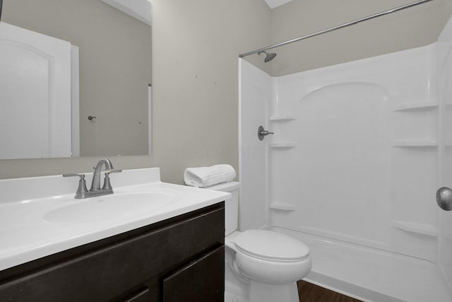 bathroom featuring hardwood / wood-style floors, vanity, toilet, and walk in shower