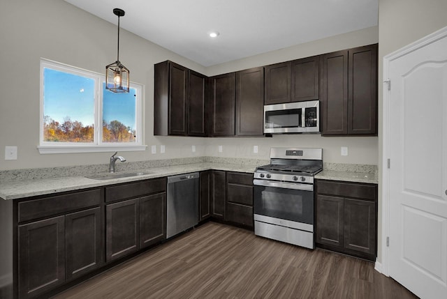 kitchen featuring pendant lighting, dark hardwood / wood-style flooring, stainless steel appliances, and sink