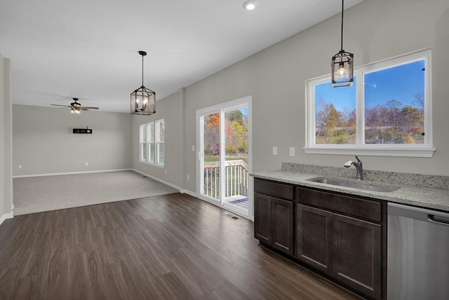 kitchen featuring dark hardwood / wood-style flooring, pendant lighting, stainless steel dishwasher, and ceiling fan with notable chandelier