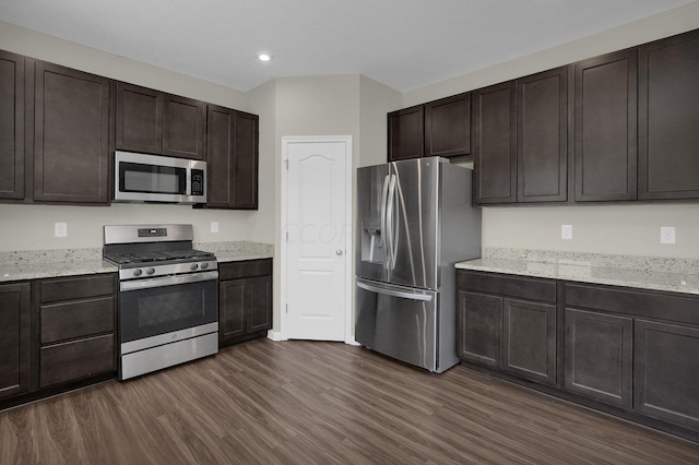 kitchen with light stone counters, dark hardwood / wood-style flooring, dark brown cabinetry, and stainless steel appliances