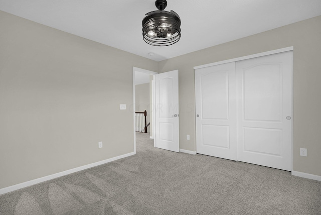 unfurnished bedroom featuring light colored carpet and a closet