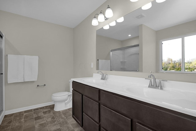 bathroom featuring vanity, an enclosed shower, and toilet