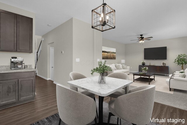 dining room with ceiling fan with notable chandelier and dark hardwood / wood-style floors