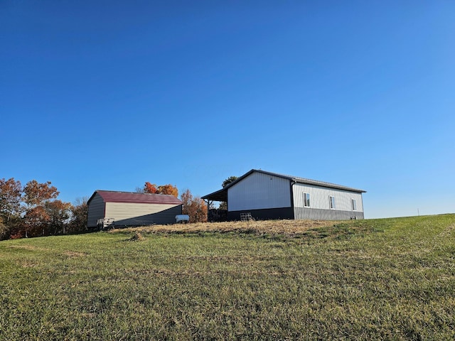 view of side of home featuring an outdoor structure and a yard