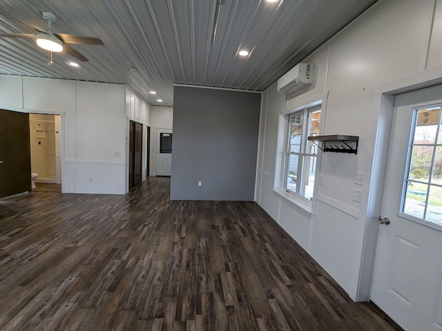 empty room featuring dark wood-type flooring, recessed lighting, a wall mounted air conditioner, and ceiling fan