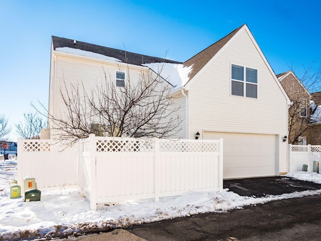 snow covered property featuring a garage