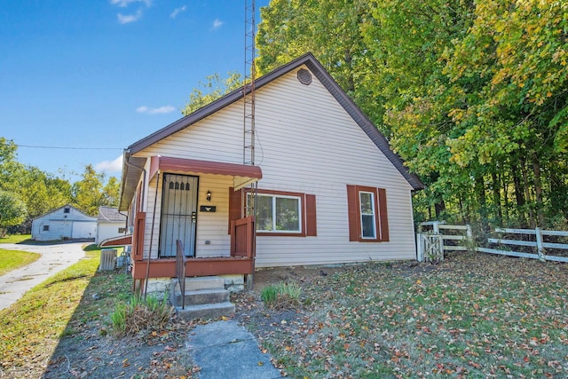 bungalow featuring covered porch and a front lawn