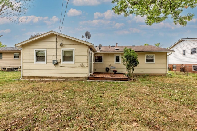 rear view of house featuring a yard and a deck