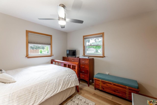 bedroom with multiple windows, ceiling fan, and light wood-type flooring