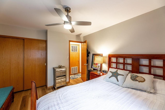 bedroom with hardwood / wood-style floors, ceiling fan, and a closet