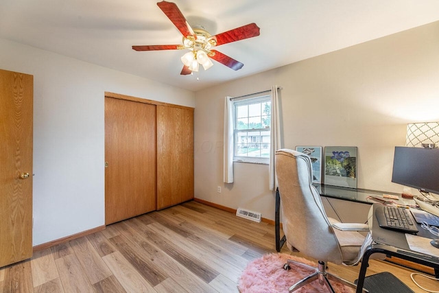 unfurnished office with ceiling fan and light wood-type flooring