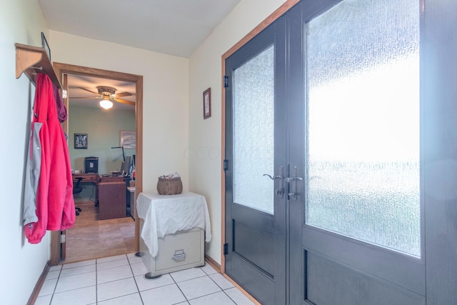 entryway with plenty of natural light, light tile patterned flooring, ceiling fan, and french doors